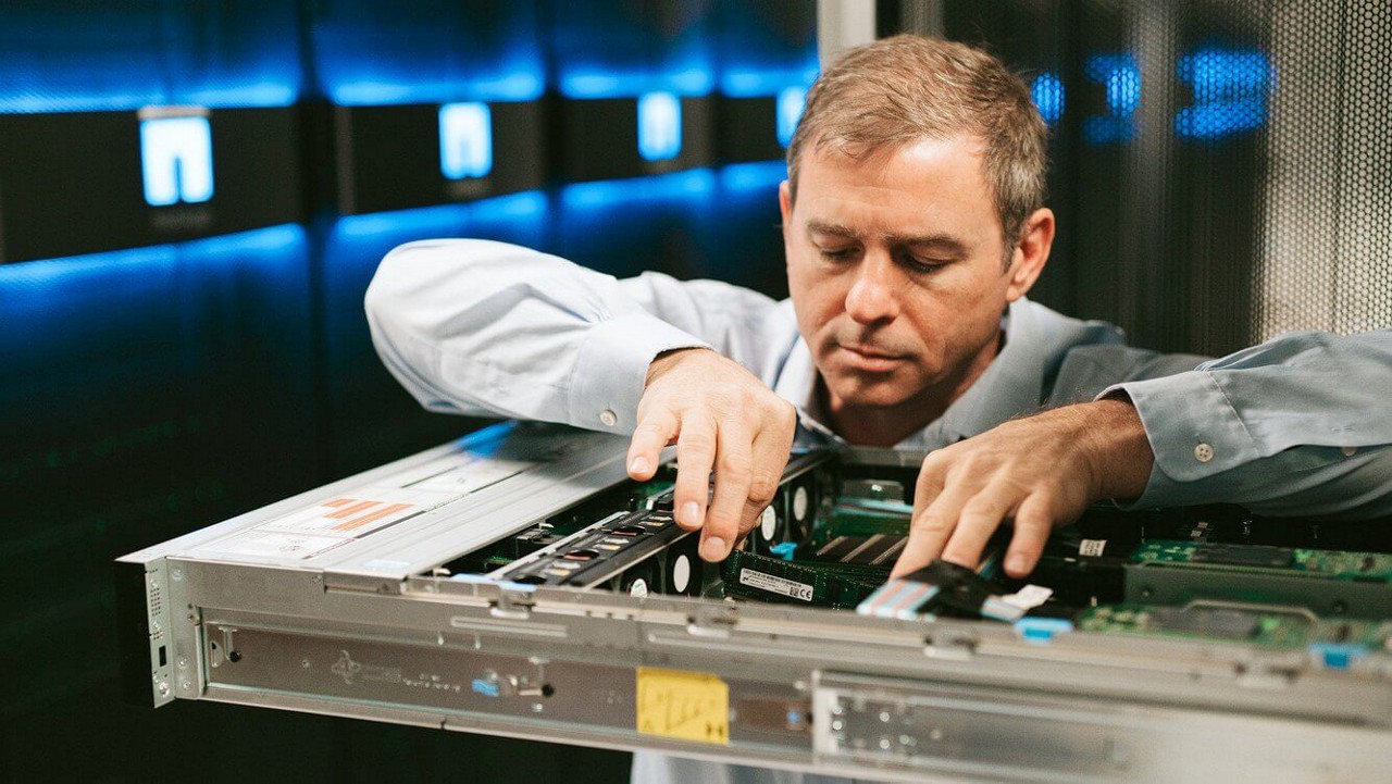 Man inserting memory module in data bank tray